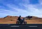 man riding motorcycle at vast land during daytime
