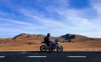 man riding motorcycle at vast land during daytime