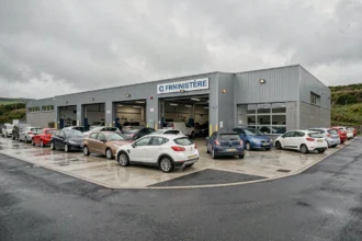 Vue extérieure d'un centre de contrôle technique dans le Finistère avec des voitures garées devant les baies d'inspection