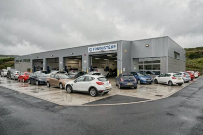 Vue extérieure d'un centre de contrôle technique dans le Finistère avec des voitures garées devant les baies d'inspection