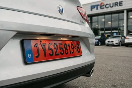 Plaque d'immatriculation rouge temporaire fixée sur un véhicule neuf dans une concession automobile en France